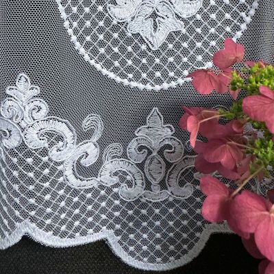 Stilvoll weiß bestickte Gardine mit ornamentalem Muster am Boden