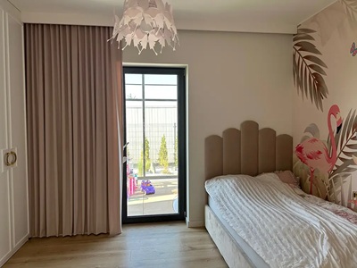 Ein Mädchenzimmer in hellen Farben mit rosa Vorhängen