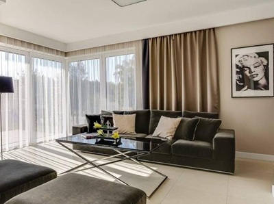 Modernes Wohnzimmer mit großen Fenstern, maßgefertigten Gardinen und beigen Verdunkelungsvorhängen